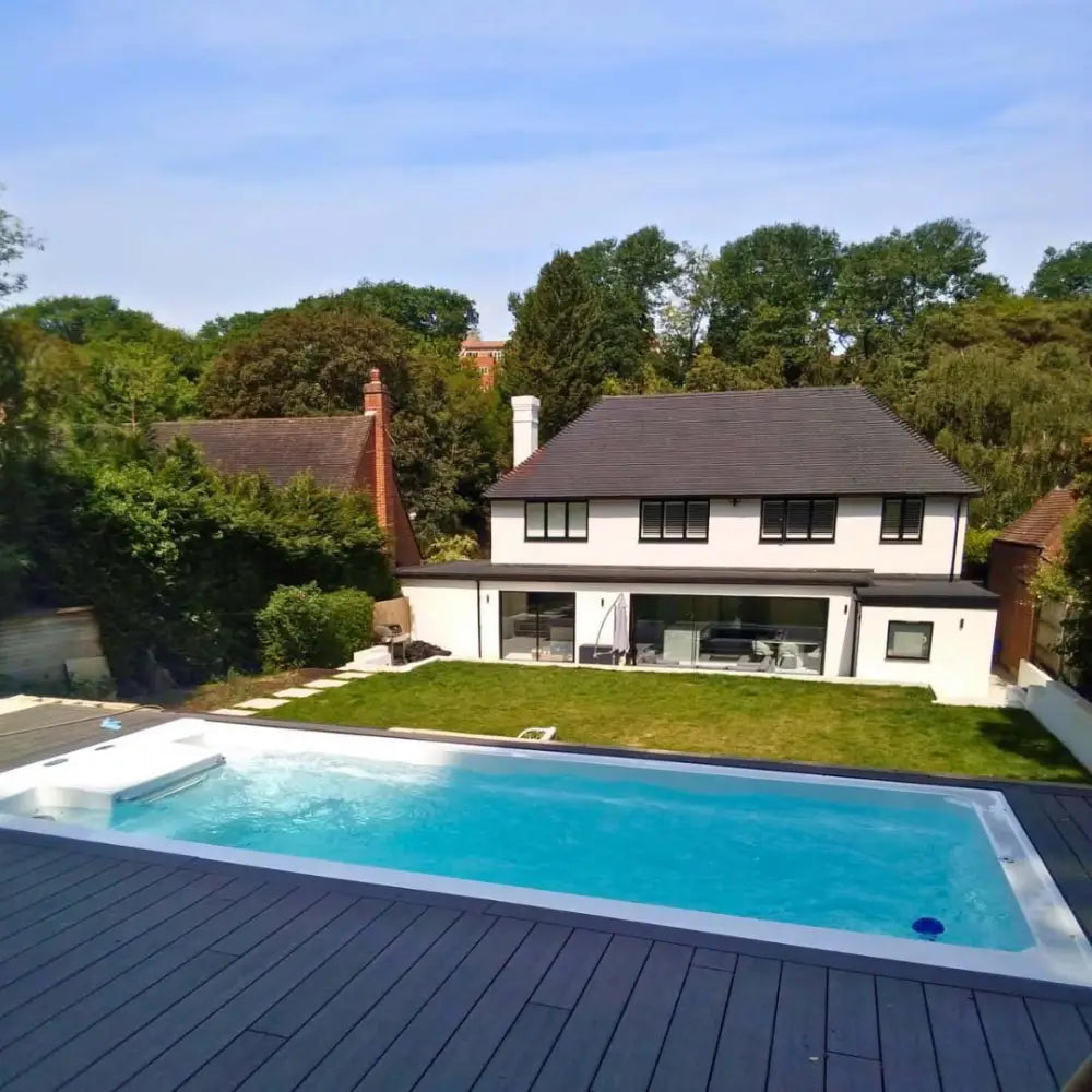 PassionSpa Turbine 6 lyxig swimspa med klarblått vatten och vit kant på grå trädäck